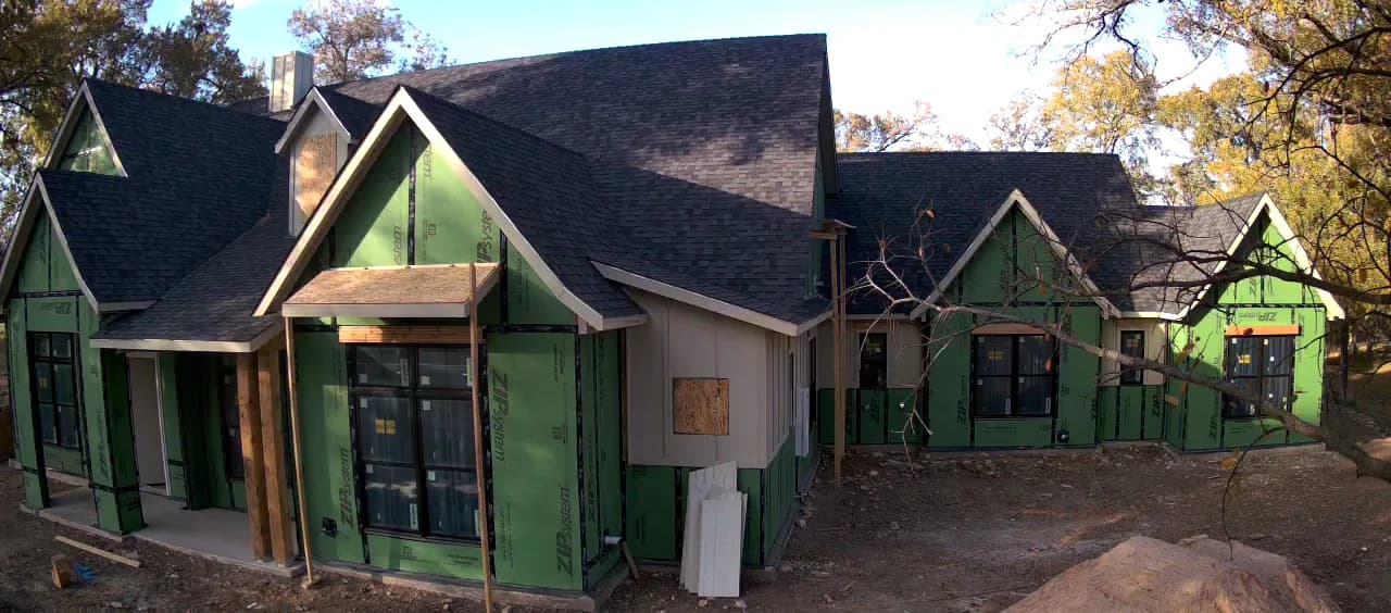 Trim boards and paneling going on over the sheathing.