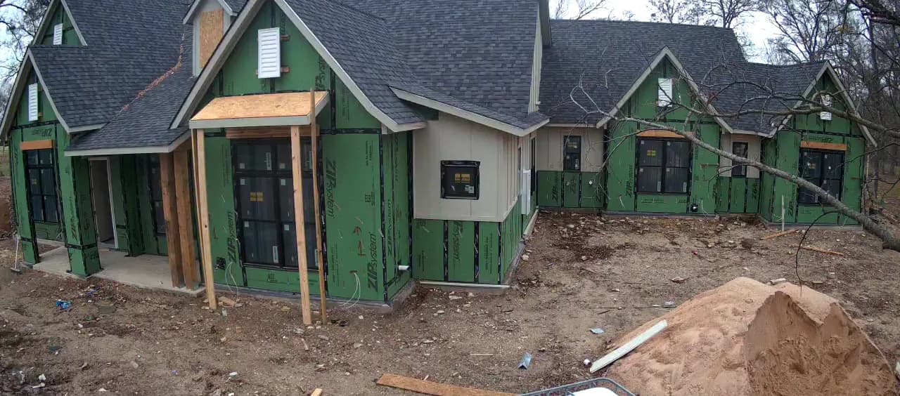 Sheathing and paneled sections across the elevation, the timber entry posts standing.