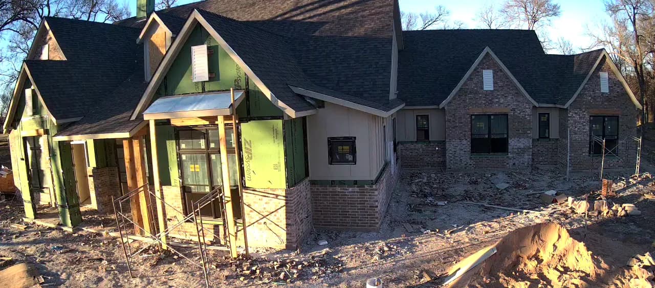 Brick across one wing and up to the windows, scaffolding standing at the entry.